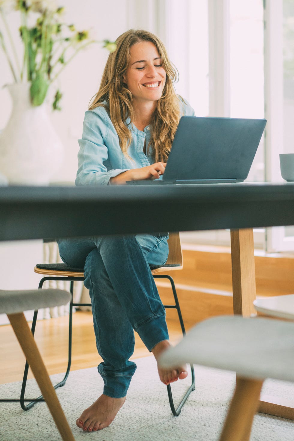 games to play on zoom - Smiling young woman using laptop at home