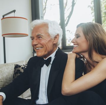 jonge vrouw met oude man lachend op de bank