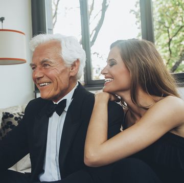 jonge vrouw met oude man lachend op de bank