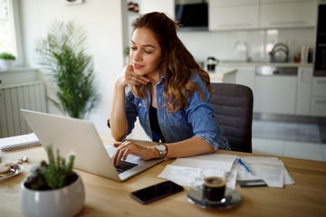 mujer sentada en un escritorio con un ordenador portatil
