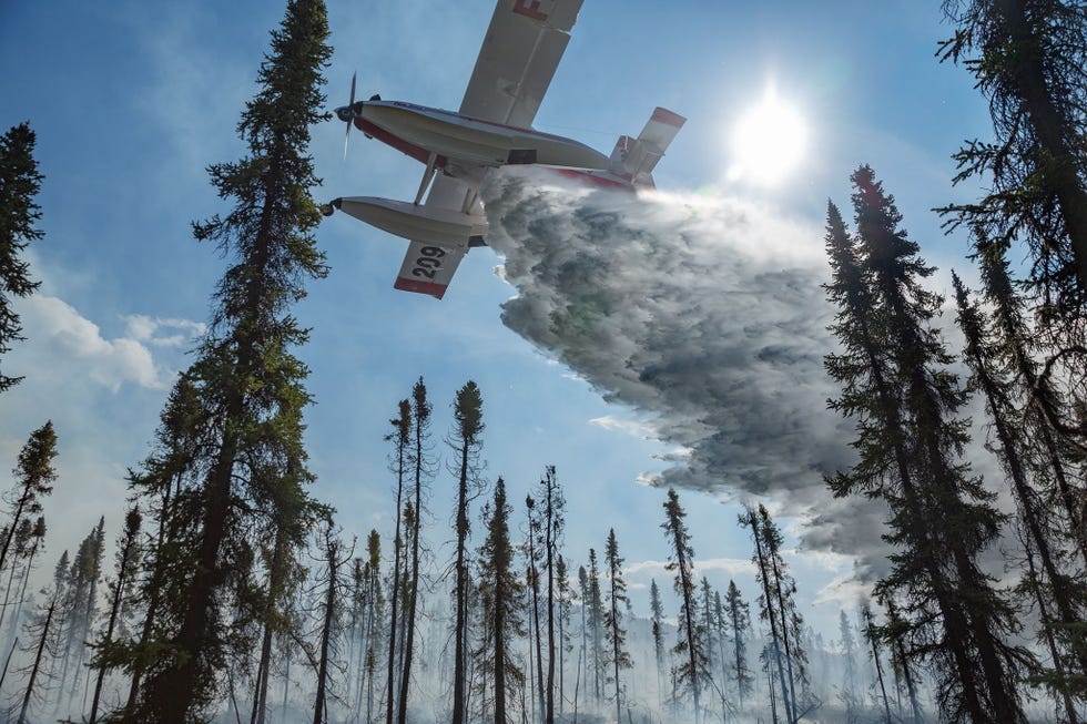 In het Brooksgebergte assisteert een Fire Boss brandweerlieden die op de grond Fire 320 bestrijden juni 2016 Het eenmotorige blusvliegtuig is uitgerust met drijvers die om de paar minuten drieduizend liter water lossen en een nieuwe lading opnemen in dit geval uit het Iniakuk Lake
