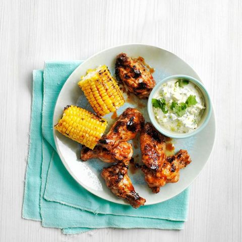 smokey grilled chicken wings with corn on the cob on the side