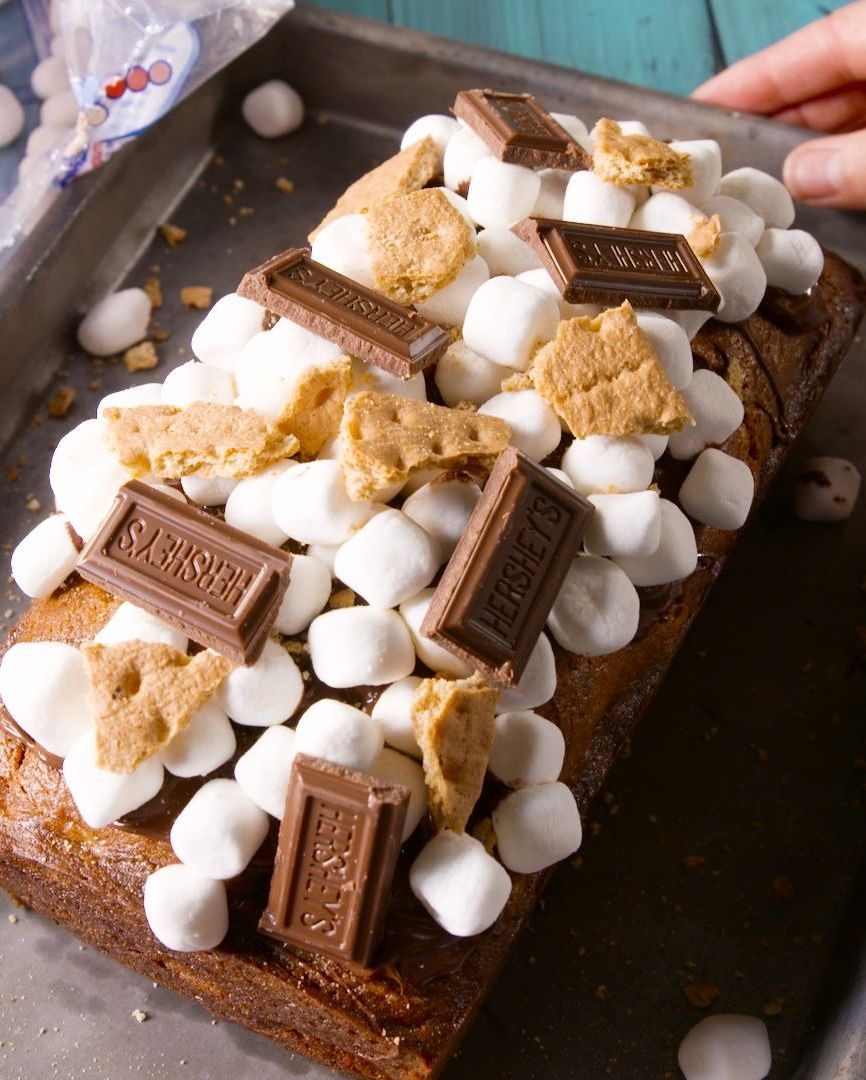 a loaf of banana bread topped with pieces of hershey bar mini marshmallows and graham cracker pieces
