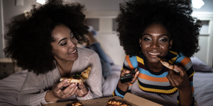 women eating pizza in bed