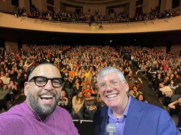 a crowd of people in a theater some waving during a live event