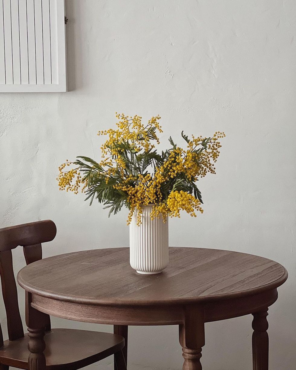 a vase of yellow flowers on a table