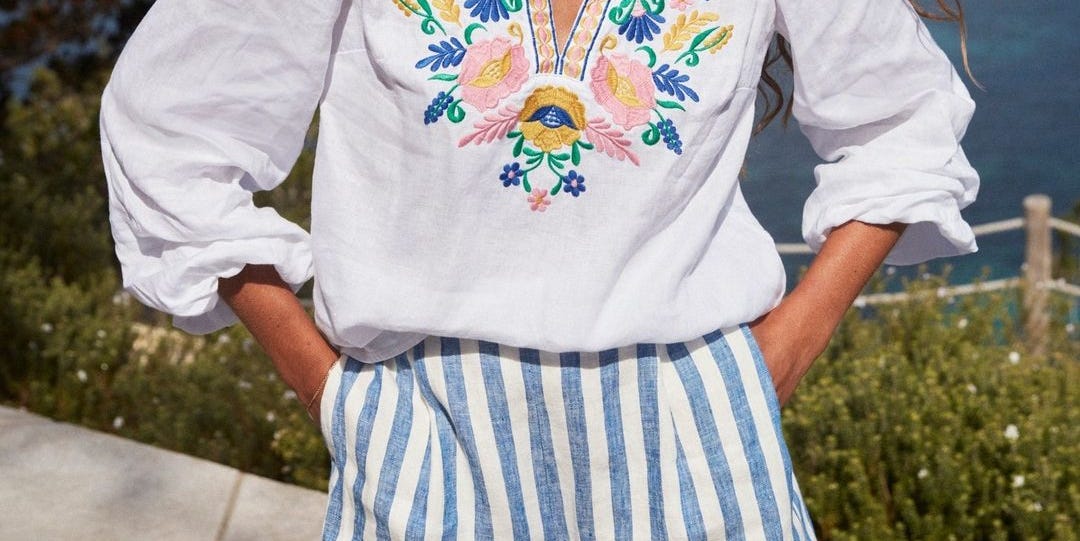 model wearing floral blouse and white and blue striped shorts boden striped shorts