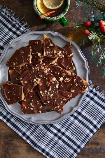 a silver plate holds pieces of chocolate almond bark, topped with chopped almonds