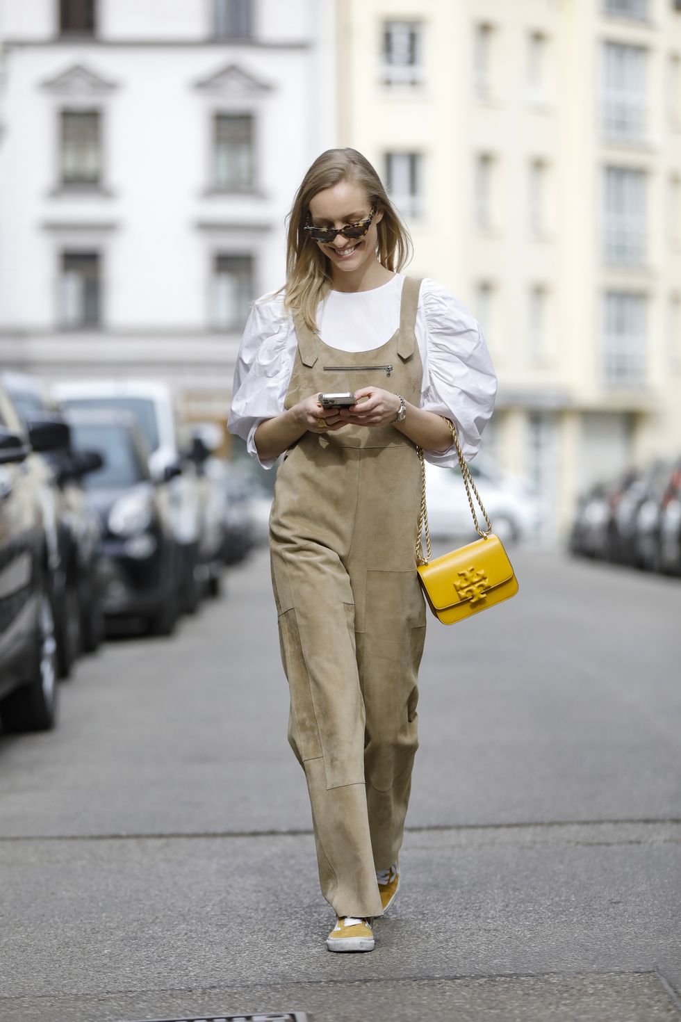 munich, germany   march 03 model marlies pia pfeifhofer wearing a white blouse by zara, khaki colored loose fitting velvet lambskin dungarees spring summer 21 collection by longchamp, sunglasses by marni, a yellow bag with gold chain detail by tory burch, yellow and white sneaker by vans and a gold ring by ole lynggaard during a street style shooting on march 3, 2021 in munich, germany photo by streetstyleshootersgetty images