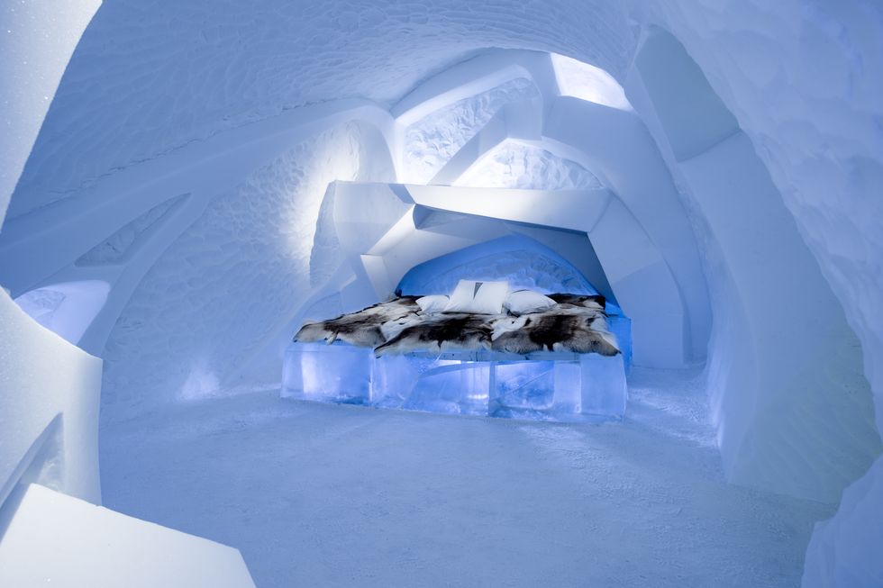 interior view of bedroom at ice hotel with bed covered in furs