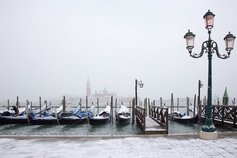 snow on venetian gondolas, st mark square, venice, italy
