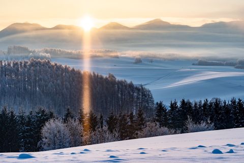 Het was die ochtend  31 graden in Hokkaido in Japan Toen de zon boven de top van de berg uitkwam ontstond er een zonnezuil