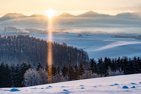 Het was die ochtend 31 graden in Hokkaido in Japan Toen de zon boven de top van de berg uitkwam ontstond er een zonnezuil