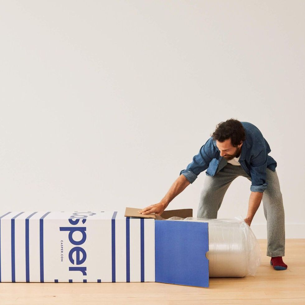 a man leaning over a stack of blue and white boxes
