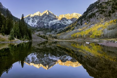 snowcapped maroon bells mountains with reflection and fall foliage aspen colors at sunrise