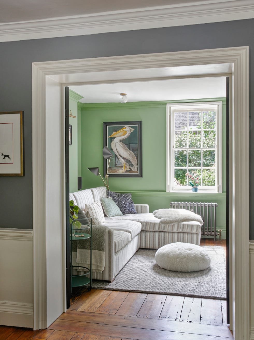 l shaped sofa and poof in pale green room
