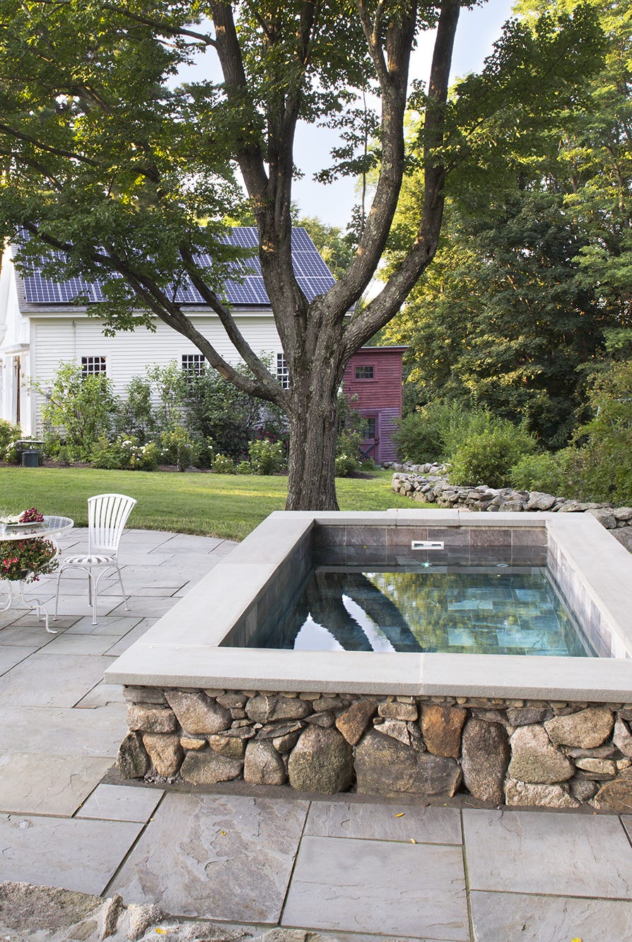 a hot tub with a fire pit and chairs in a yard with trees a hot tub with a fire pit and chairs in a yard with trees