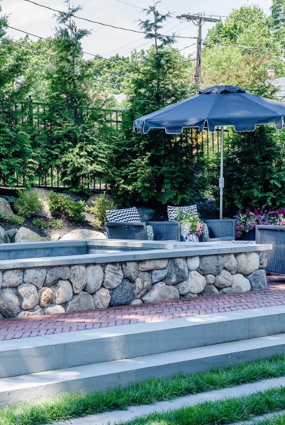 a stone fountain with umbrellas a stone fountain with umbrellas