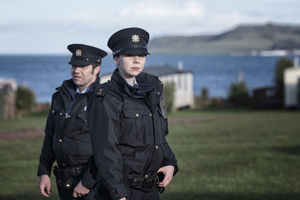 two police officers standing outdoors near a body of water