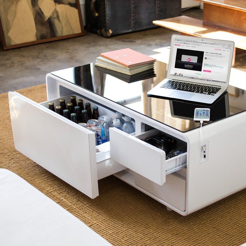 white coffee table with fridge drawer open, and laptop on top of it