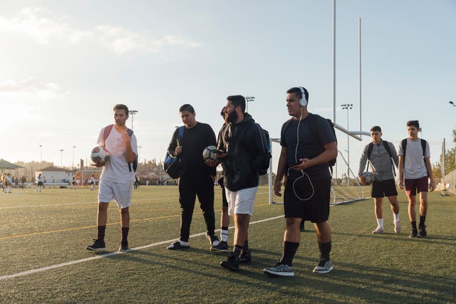 varios jugadores de fútbol se retiran del campo con el balón en la mano tras un partido