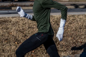 person running outdoors wearing athletic attire and makeshift mittens
