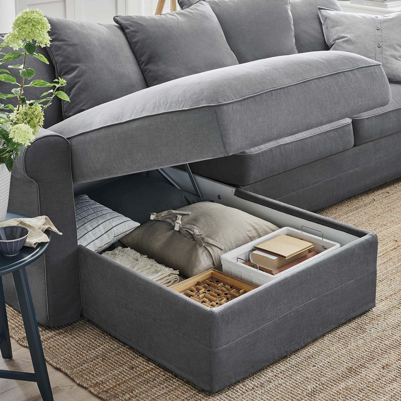 sofá gris con chaise longue y arcón de almacenaje