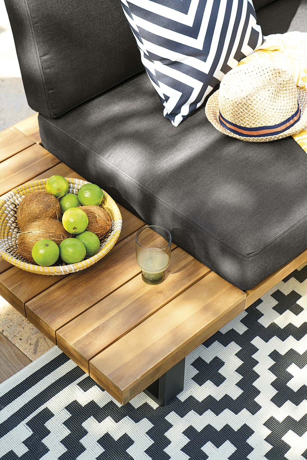 sofá exterior de madera y cojines negros