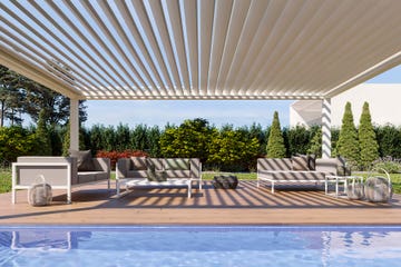 sofá exterior junto a la piscina bajo una pérgola