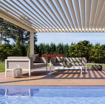 Sofá exterior junto a la piscina bajo una pérgola sofá exterior junto a la piscina bajo una pérgola
