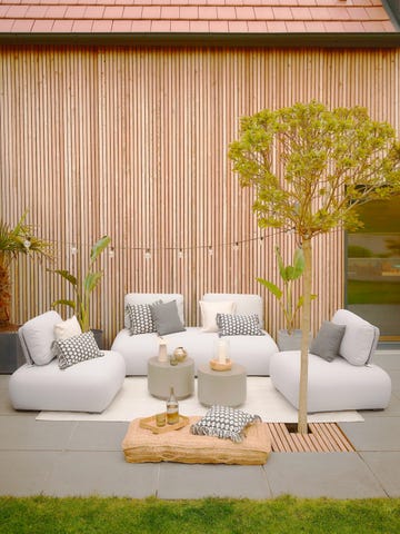 estar exterior con sillones modernos y guirnalda de luces