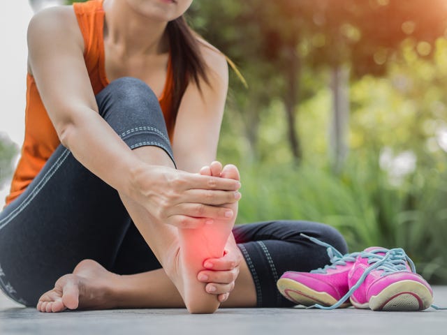 een vrouw masseert haar voet na het hardlopen