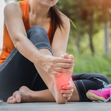 een vrouw masseert haar voet na het hardlopen