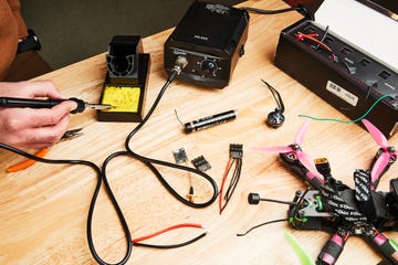 soldering iron, sponge, solder and drone components on work surface
