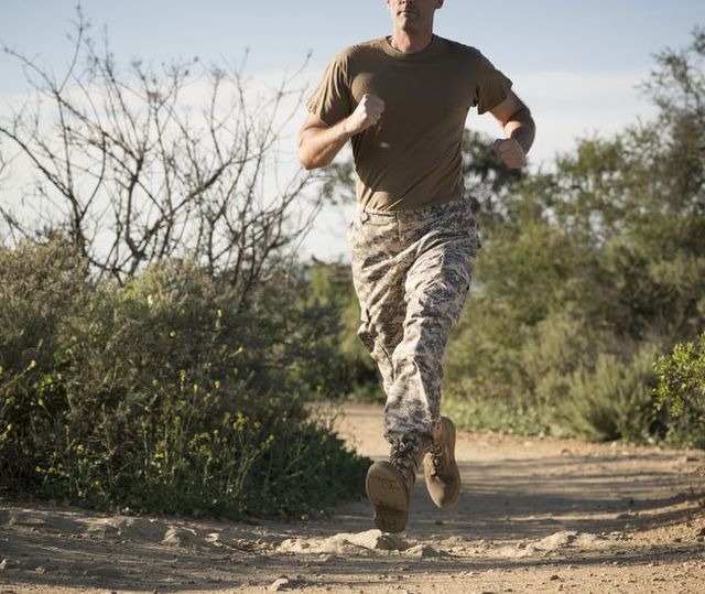 Soldier wearing combat clothing running, Runyon Canyon, Los Angeles, California, USA