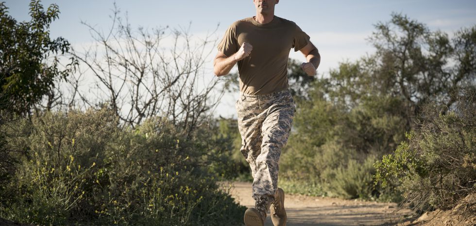 Soldier wearing combat clothing running, Runyon Canyon, Los Angeles, California, USA