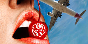 a red cherry in a person's mouth with a plane in the background