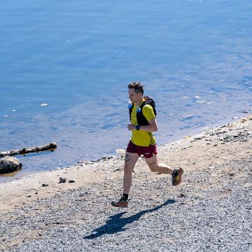 ultrarunner running along a river bank, guide to ultrarunning