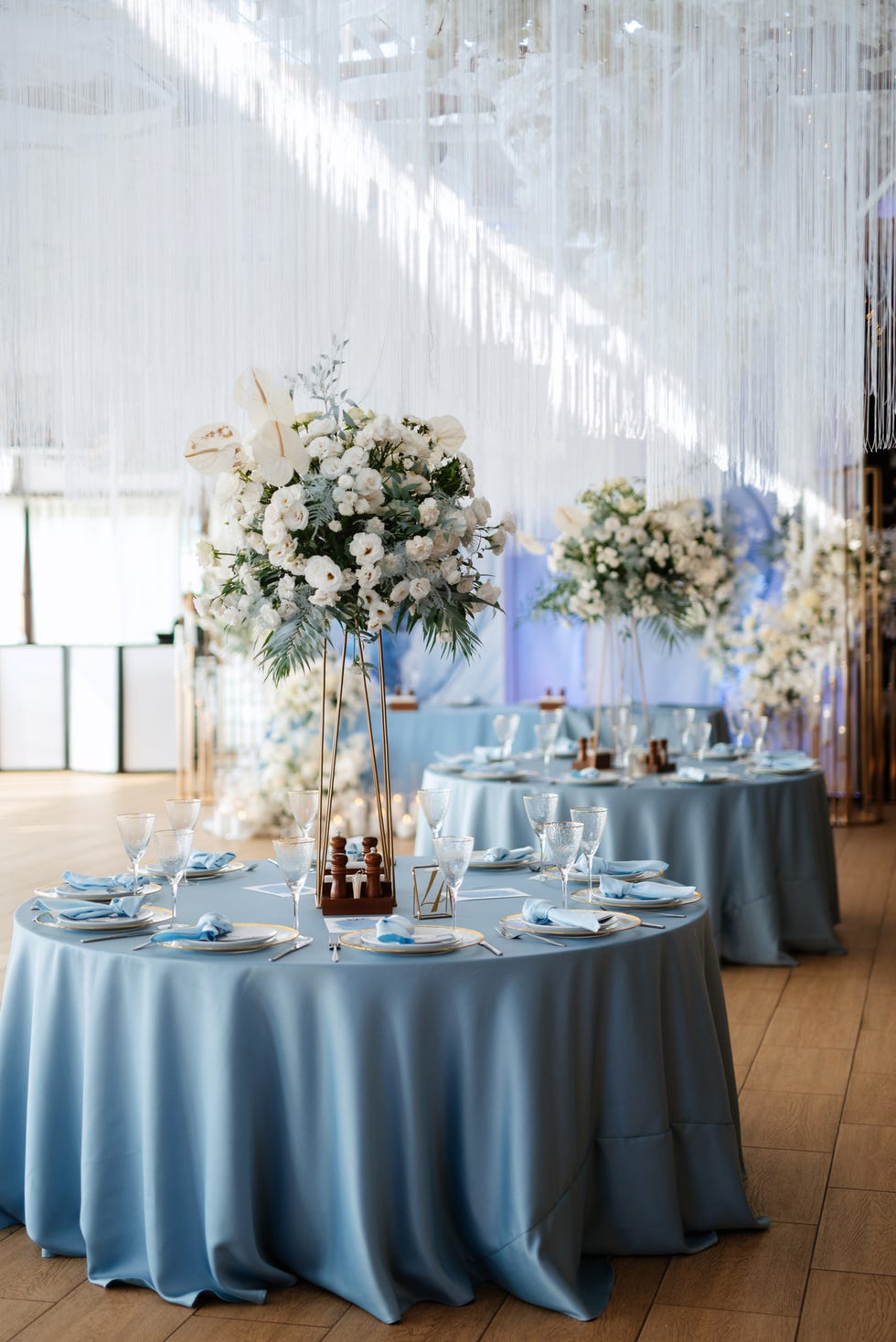 banquet hall for weddings decorated with blue tablecloths, napkins, flowers and other elements