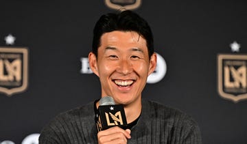son heung min holds a branded microphone and smiles as he attends a press conference announcing his signing for lafc