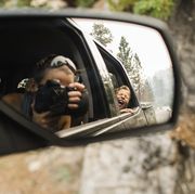 son screaming while mother photographing with camera reflecting on side view mirror