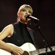 taylor swift on stage playing the guitar