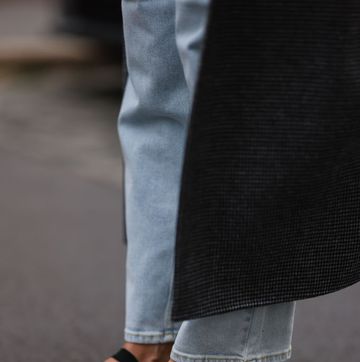 a woman on the street in berlin wearing dark pink satin ballet flats by miu miu with jeans and coat in a roundup of the best satin ballet flats 2024