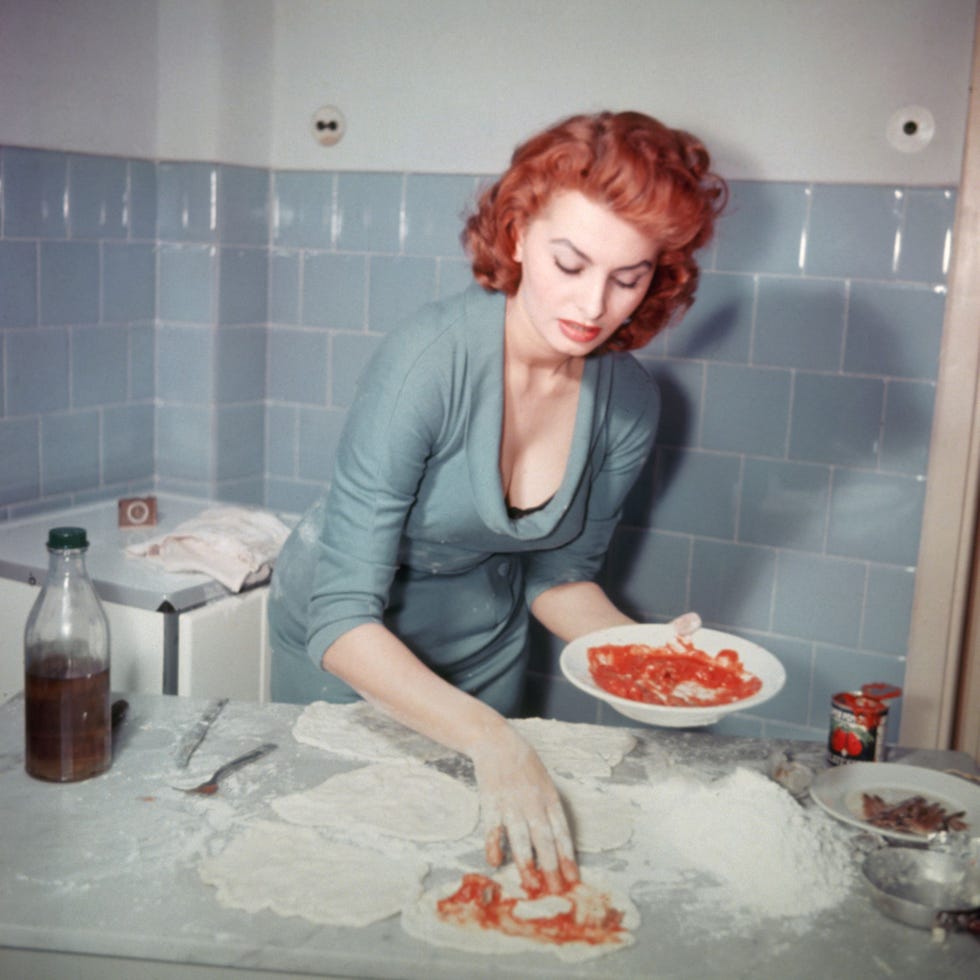 sophia loren, en 1965, cocinando, sus delicadas manos embadurnadas de harina y tomate