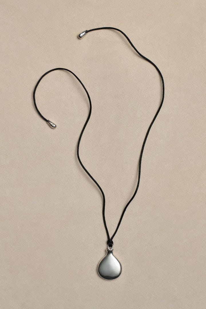 a sleek teardropshaped pendant on a black cord