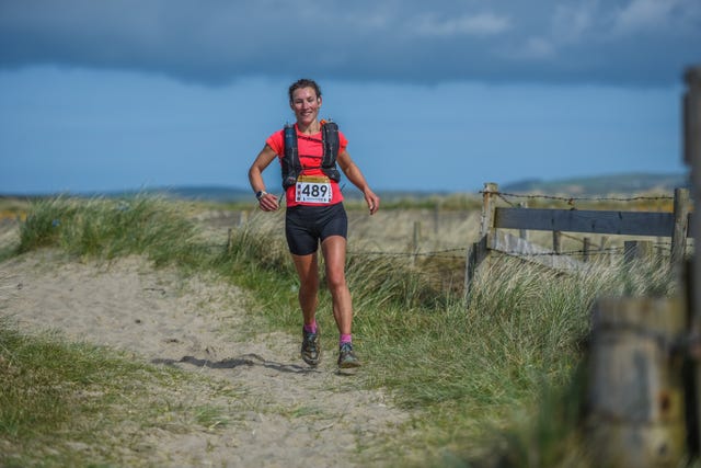 smiling woman runs in a rural setting