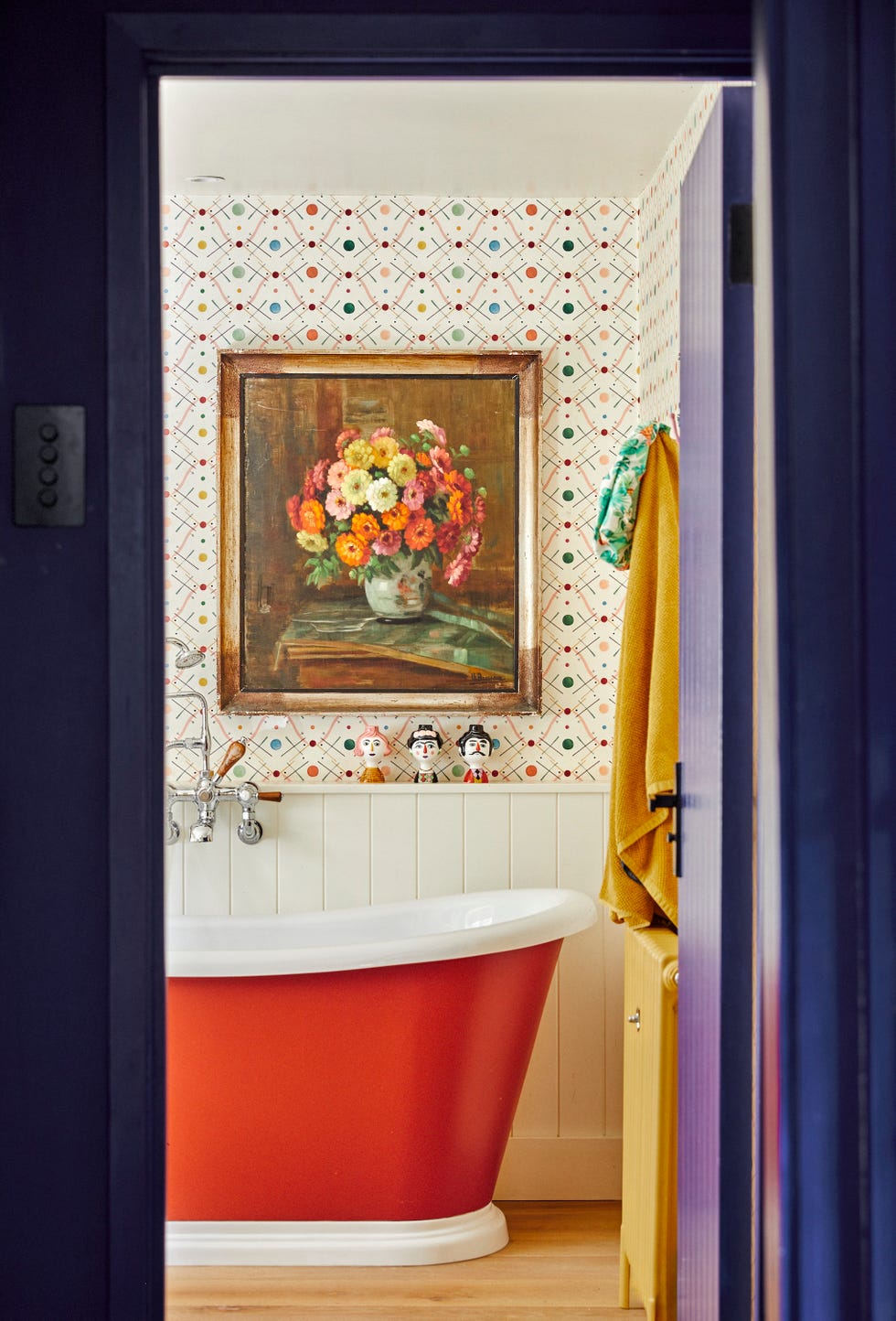 a vibrant bathroom featuring a colorful bathtub and floral artwork