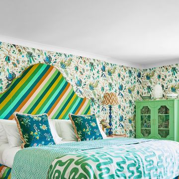 a colourful pattern clash maximalist bedroom with a bed and a chair