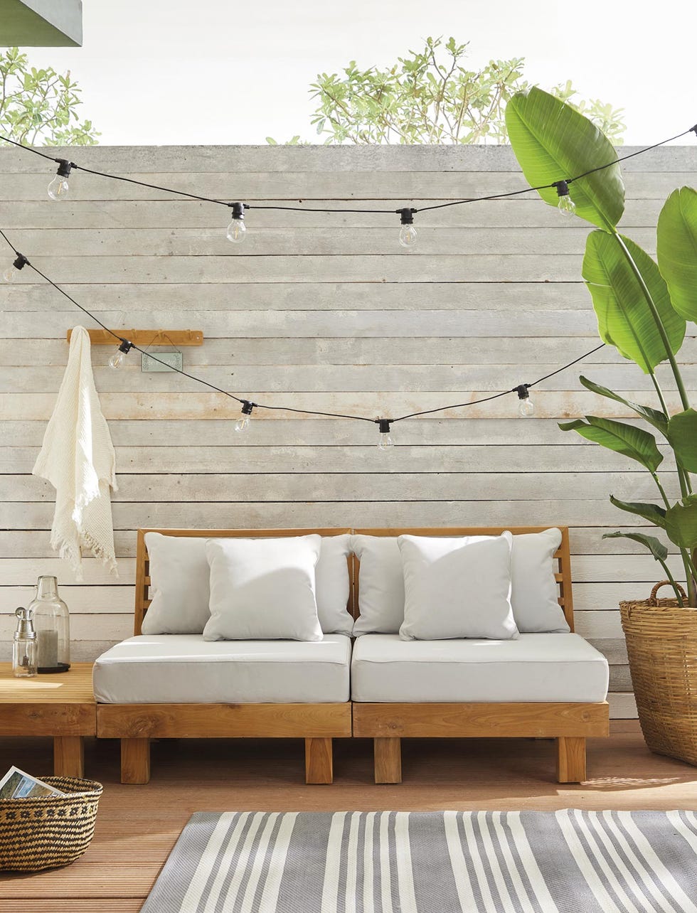 terrazas y jardines porche moderno con sofá y guirnalda de luces