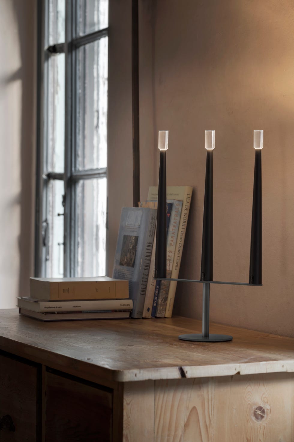 a desk with a lamp and books on it